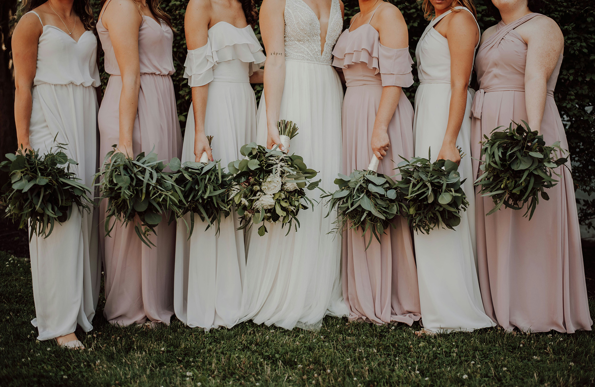 Brud og forlovere i matchende kjoler i forskjellig snitt - foto: Unsplash / Katelyn Macmillan